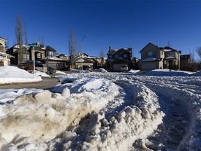 Weeks after the last heavy snowfall, piles of snow in some Calgary streets makes it difficult for drivers to reach the main streets on Thursday, Jan. 7, 2021. Pictured is a street in the northwest community of Royal Oak.