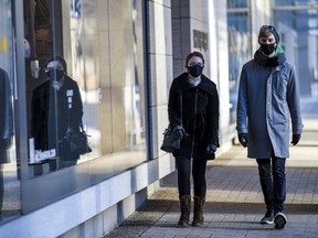 Two masked pedestrians take a walk in downtown Calgary on Saturday, Jan. 9, 2021.