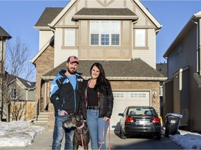 Brodie Duczek, his fiancé Darcie Cooper, and their dog Skylar pose for a photo outside their newly purchased house in Sage Hill on Saturday, January 9, 2021. Azin Ghaffari/Postmedia