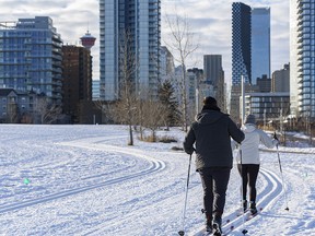 Two cross-country skiers spend the afternoon skiing at the East Village Nordic Loop with downtown Calgary in the background on Saturday, Jan. 23, 2021.