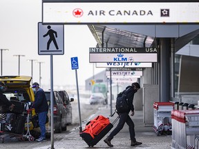 Masked travellers arrive at the International terminal in YYC (Calgary International Airport) on Friday, January 29, 2021.