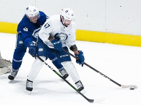 Olli Juolevi #48 of the Vancouver Canucks tries to check Sven Baertschi #47 off the puck during a drill on the first day of the Vancouver Canucks NHL Training Camp at Rogers Arena on Jan. 4, 2021 in Vancouver, British Columbia, Canada.