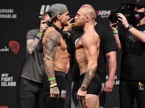 Dustin Poirier and Conor McGregor face off during the UFC 257 weigh-in at Etihad Arena on UFC Fight Island in Abu Dhabi on Friday, Jan. 22, 2021.