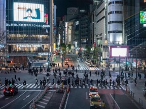 Pedestrians walk at crossing of Shibuya district in Tokyo on Jan. 8, 2021, during the first day under a state of emergency over the COVID-19 coronavirus pandemic.
