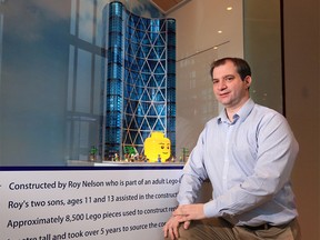 Roy Nelson poses with his Lego sculpture of The Bow building in its new home on display in the lobby of of the real Bow on Monday, Jan. 18, 2021. HR REIT, the owners of The Bow building, purchased Nelson’s work as a piece of public art for the building. Nelson built it with the help of his 11- and 13 year-old sons and it includes 8,500 pieces of which 2000 are windows.