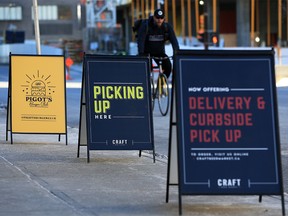 Signs mark a curbside pick-up area for restaurants along 10th Avenue S.W. on Wednesday, Jan. 20, 2021. Diners will be able to eat in for Valentine's Day, but one Alberta specialist says it's not without risks, given the new more contagious variants.