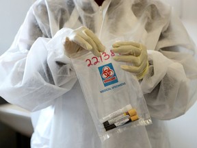 A health worker holds a COVID-19 sample collection kit in Johannesburg, South Africa, Aug. 27, 2020.