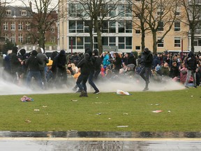 Police use a water canon during a protest against restrictions put in place to curb the spread of the coronavirus disease (COVID-19), in Amsterdam, Netherlands Jan. 24, 2021.