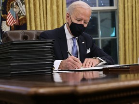 U.S. President Joe Biden signs a series of executive orders in the Oval Office, including an order withdrawing the construction permit for the Keystone XL pipeline, on Jan. 20, 2021.