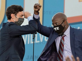 Democrats Jon Ossoff (L) and Raphael Warnock greet each other during a rally with US President-elect Joe Biden in Atlanta, Georgia, on January 4, 2021.