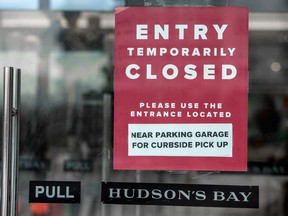 A sign on a Hudson's Bay store, closed for all but curbside pickup, in Toronto in December. Get used to the closures, says columnist Chris Nelson. We'll be playing that card for some time to come.
