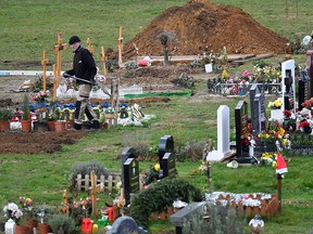 A worker digs graves at a cemetery in London, Britain, on Jan. 11, 2021.