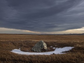 A glacial erratic catches the last rays of sun underneath a chinook arch west of Stavely, Ab., on Tuesday, Jan. 19, 2021.
