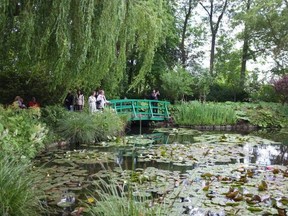 Visitors walk over a bridge at Giverny, Claude Monet's home and gardens in Normandy, France.