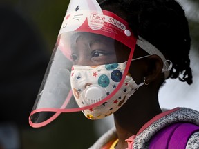 Nancy Murphy, 5, wears a full mask and face shield as she waits in line for her kindergarten class to enter Portage Trail Community School in Toronto on Sept. 15, 2020.