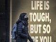 A pedestrian walks past Hudson's Bay on Toronto's Queen Street  during the COVID-19 pandemic, Friday Jan. 15, 2021.