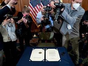 Photographers take pictures of the article of impeachment against President Donald Trump prior to it being signed at the U.S. Capitol on January 13, 2021 in Washington, DC.