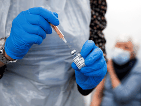 A health worker prepares to administer a dose of the Oxford/AstraZeneca COVID-19 vaccine in Widnes, Britain.