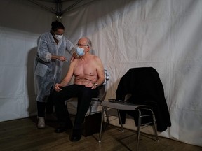 An elderly man receives an injection of a COVID-19 vaccine at a vaccination centre in Vesoul, eastern France, on Jan. 18, 2021.