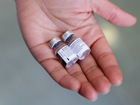 A pharmacist holds vials of the Pfizer-BioNTech COVID-19 vaccine.