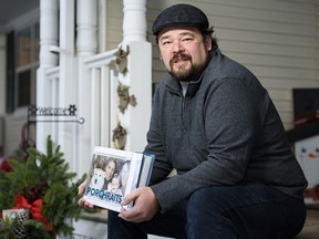 Photographer Neil Zeller poses for a photo with his book Porchraits ... on his porch.