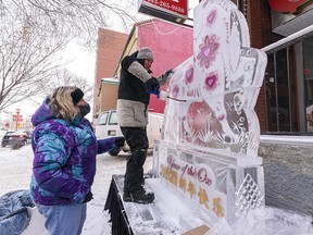 Ice sculptor Lee Ross and his wife and assistant Jana Ross install their ice sculptor celebrating Chinese New Year and the year of the Ox in Chinatown on Friday, February 12, 2021. The Chinatown ice sculpture showcase is a part of Chinook Blast, a new mid-winter festival in Calgary.