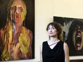 Artist Jennifer Peters poses for a photo in front of some of her works at her exhibition at cSPACE.