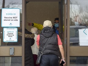 People arrive at the old Greyhound terminal for their COVID-19 vaccination appointment on Friday, Feb. 26, 2021. COVID-19 vaccinations are now available for Albertans 75 and older.