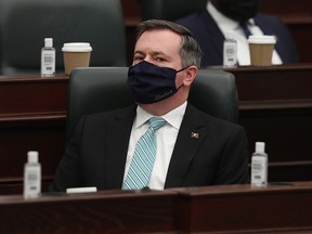 Premier Jason Kenney watches as Minister of Finance Travis Toews delivers the 2021 Alberta Provincial budget at the Alberta Legislature, in Edmonton Thursday Feb. 25, 2021.