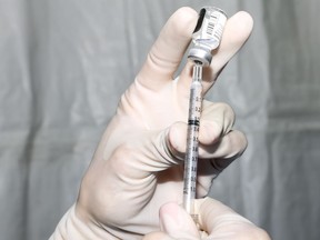 A pharmacy technician prepares a dose of the Pfizer-BioNTech COVID-19 vaccine in Denver, Colorado.