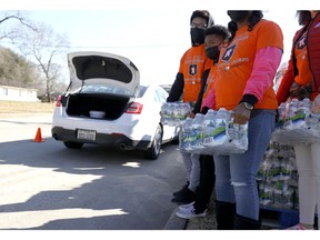 HOUSTON, TEXAS - FEBRUARY 20: Volunteers prepare to load cases of water into cars during a water distribution at the Astros Youth Academy on February 20, 2021 in Houston, Texas. Much of Texas is still struggling with historic cold weather, power outages and a shortage of potable water after winter storm Uri swept across 26 states with a mix of freezing temperatures and precipitation. Many Houston residents do not have drinkable water at their homes and are relying on city water giveaways.