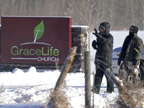 Two men keep unwelcome visitors from entering the property at GraceLife Church in Parkland County, just east of Edmonton, on Sunday February 7, 2021. The church has defied government pandemic restrictions multiple times and held a church service on this day.