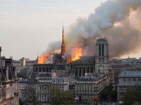 Smoke billows as flames burn through the roof of the Notre-Dame de Paris Cathedral on April 15, 2019, in the French capital Paris.