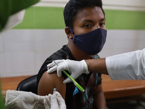 Medical staff inoculate a man with a COVID-19 coronavirus vaccine at the Mugda General Hospital as vaccinations began across the country, in Dhaka on Feb. 7, 2021.