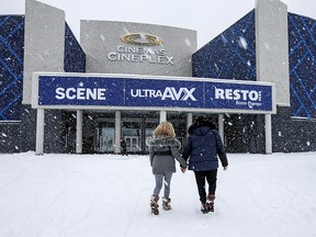 People walk into a cinema as Quebec allows the reopening of movie theatres but not the selling of food and drinks, which includes popcorn, during the outbreak of the coronavirus disease (COVID-19) in Kirkland, a suburb of Montreal, Quebec, Canada on Feb. 27, 2021.