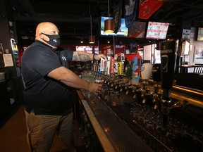 Owner Mike Shupenia was back to pouring beers at Side Street Pub and Grill in Kensington during the next stage of reopening in Calgary on Monday, February 8, 2021.