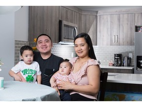 Ian Ellis Buenaventura and Juliet Domingo, with their children James Liam, 2, and Jio, in their Airdrie townhome.