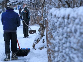 Sunnyside residents clear sidewalks after an overnight snowfall on Wednesday, February 3, 2021.