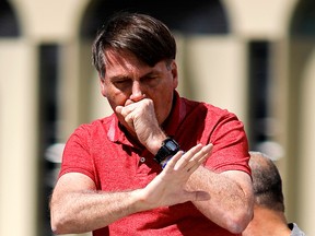 Brazilian President Jair Bolsonaro coughs as he speaks after joining his supporters in a protest against quarantine and social distancing measures  on April 19, 2020.