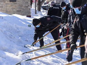 Calgary Police rake the snow for evidence at the scene of a suspicious death at the parking lot of Mazaj Lounge and Restaurant on Macleod Trail on Saturday, Feb. 20, 2021.