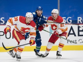 Feb 13, 2021; Vancouver, British Columbia, CAN; Vancouver Canucks forward Adam Gaudette (96) battles with Calgary Flames forward Byron Froese (38) and forward Joakim Nordstrom (20) in the first period at Rogers Arena. Mandatory Credit: Bob Frid-USA TODAY Sports ORG XMIT: IMAGN-445146