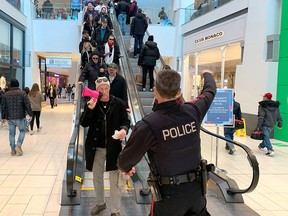 Police attempt to disperse an anti-mask protest in Chinook Mall in Calgary on Saturday, Feb. 13, 2021.