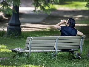 A man enjoys a beverage in Toronto’s Trinity Bellwoods Park.
