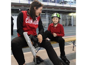 Olympic speed skater Anastasia Bucsis gives Jackson Jones, 8, from the Calgary Speed Skating Association , a hand tying up his skates after the 2014 Canadian Olympic Long-Track Speed Skating Team names were announced at the Olympic Oval in Calgary. Calgary Herald files