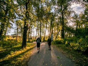 Paralympian Cody Dolan and a member of AccessNow walk along the Bow River Pathway in Calgary in summer 2020 to map the area for an accessibility improvement project in along the Trans Canada Trail.