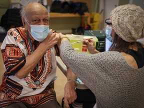 Abdul Makalai, 86, receives the COVID-19 vaccine from registered nurse Corrina Bennett Silvera Aspen in Calgary.