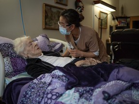 Dorothy Boothman, 98, receives a COVID-19 vaccine from registered nurse Brenda Claudio at Clifton Manor in Calgary.