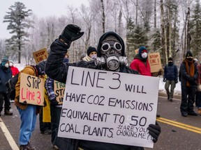 A Native American environmental activist holds a sign in front of the construction site for the Line 3 oil pipeline site near Palisade, Minnesota on January 9, 2021.