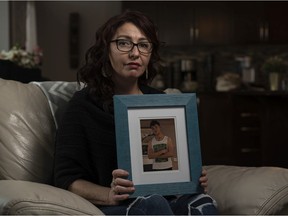 Cheryl Bulloch poses for a photo holding a framed photo of her deceased son Jacob Bulloch at her home in Airdrie on Tuesday, March 2, 2021. After years of struggling with mental health issues and addiction, Jacob died from an accidental Fentanyl overdose in November, 2020 at the age of 19. Azin Ghaffari/Postmedia
