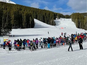 Crowds flock to the mountains from Calgary each weekend to play in the snow and to avail of the outdoor mental health benefits. Public health restrictions caused by the COVID-19 pandemic have led to canceled festivals, concerts and other events but the ski hills have remained busy this season. (pictured) Nakiska ski area long line-ups on Feb.19. Photo Marie Conboy /Postmedia.